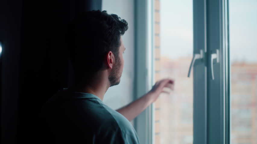 Man opening window and breathing fresh air in the morning