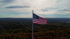 Aerial view of an American flag waving above vast autumn forest and distant hills under a dramatic cloudy sky. Castle Craig viewpoint, East Peak in USA. - Powered by Shutterstock - Get 15% off with code: PIKWIZARD15