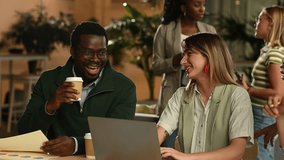Young african american businessman and caucasian businesswoman collaborating on a project. Colleagues drinking coffee and having a pleasant conversation - Powered by Shutterstock - Get 15% off with code: PIKWIZARD15