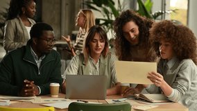 Young multicultural business team working together in a contemporary startup office. Colleagues discussing ideas, analyzing documents, and using a laptop - Powered by Shutterstock - Get 15% off with code: PIKWIZARD15