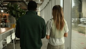 Young diverse colleagues discussing a project while walking through a bright, contemporary office space. They are engaged in conversation - Powered by Shutterstock - Get 15% off with code: PIKWIZARD15