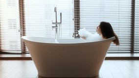 Young woman enjoying a relaxing bath in a modern bathroom for self-care routine - Powered by Shutterstock - Get 15% off with code: PIKWIZARD15