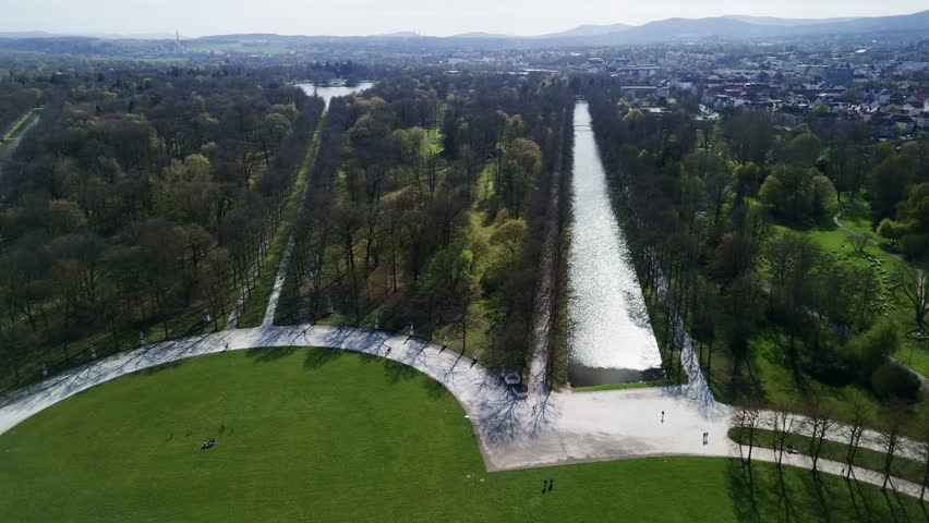 Aerial view of a park with a long canal and surrounding trees.