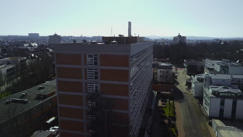 Aerial view of a cityscape with a tall building in the foreground.