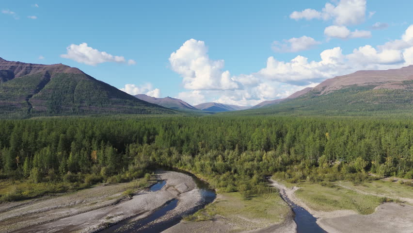 Wide drone pan across a pristine taiga valley toward purple ridges and a winding creek near Lake Lama in the Putorana Plateau, Russia. Afternoon light, clear sky, cinematic motion, strong travel appea