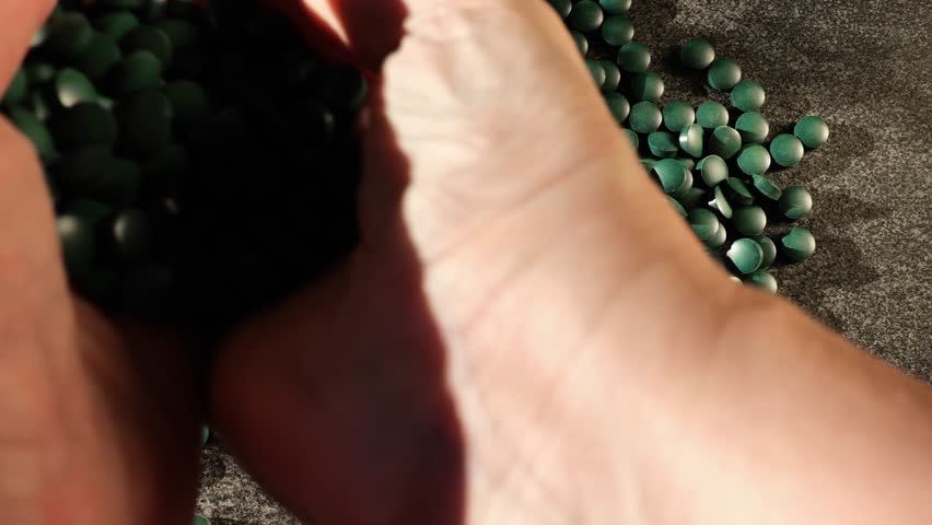 Green spirulina pills in hands. Algae in nutrition.Natural vegetarian source of protein. 4k footage