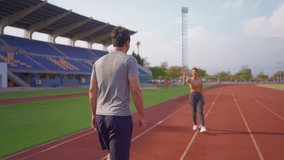 Diverse young man and woman athletes exercising together at stadium. Attractive sportswoman and male trainer making a handshake while work out and prepare for competition during training session. - Powered by Shutterstock - Get 15% off with code: PIKWIZARD15