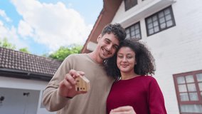 Hispanic Latina young couple holding a key and small wooden house model. Portrait of attractive man and woman standing outdoors infront of new home, symbolizing moving in, or real estate ownership. - Powered by Shutterstock - Get 15% off with code: PIKWIZARD15