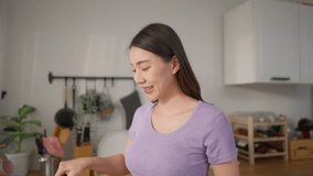 Asian pregnant wife cooking healthy food with husband in kitchen at home. Attractive expectant couple feel happy and relax, enjoy making green vegetable salad, prepare for maternity together in house. - Powered by Shutterstock - Get 15% off with code: PIKWIZARD15