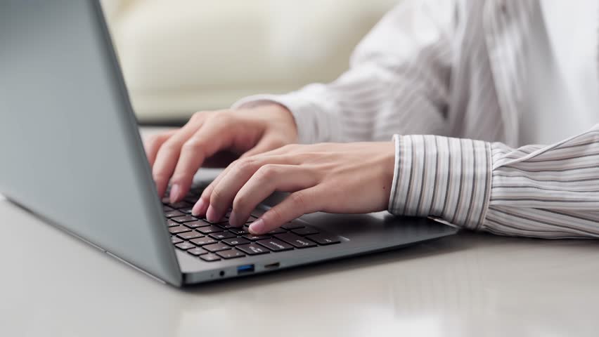 Hands of an Asian man typing