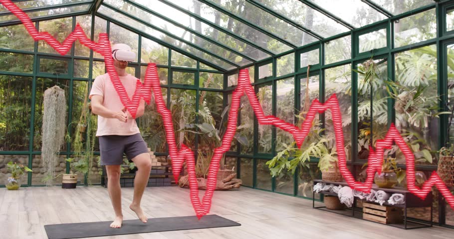 Man holding controllers and shifting weight initiating balancing with pulse graph for VR fitness. Wellness, meditation, mindfulness, technology, exercise, tranquility, harmony