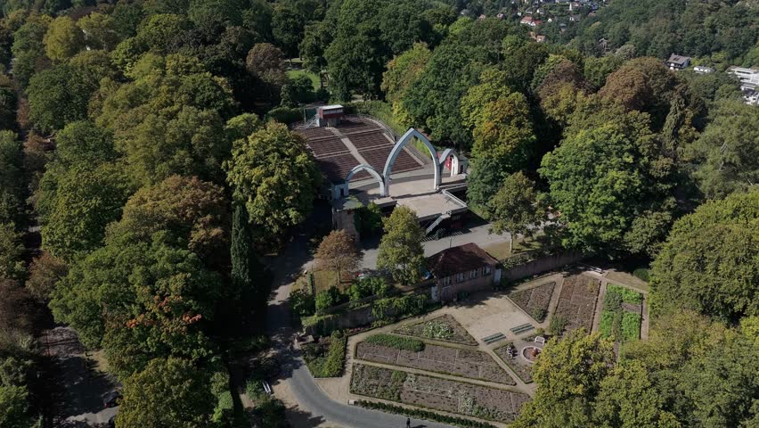 Aerial view of a botanical garden with geometric pathways and lush greenery.