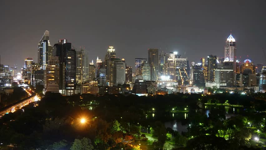 Bangkok city skyline at night with illuminated skyscrapers and parkland view