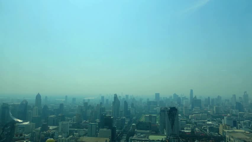 Skyline view of a sprawling city under a hazy blue sky on a sunny afternoon
