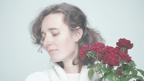 Profile of a Woman with Medium-Length Brown Hair Holding Red Roses, Transitioning from Contemplation to a Warm Smile in a Soft Background - Powered by Shutterstock - Get 15% off with code: PIKWIZARD15