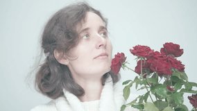 Thoughtful Reflections: Woman with Vibrant Red Roses in Softly Lit Space Exhibits Contemplative Mood and Gentle Expressions - Powered by Shutterstock - Get 15% off with code: PIKWIZARD15