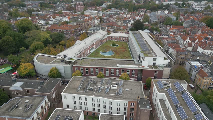 Aerial view of Leiden University in the Netherlands, showing its modern and historic buildings surrounded by trees and the city center.