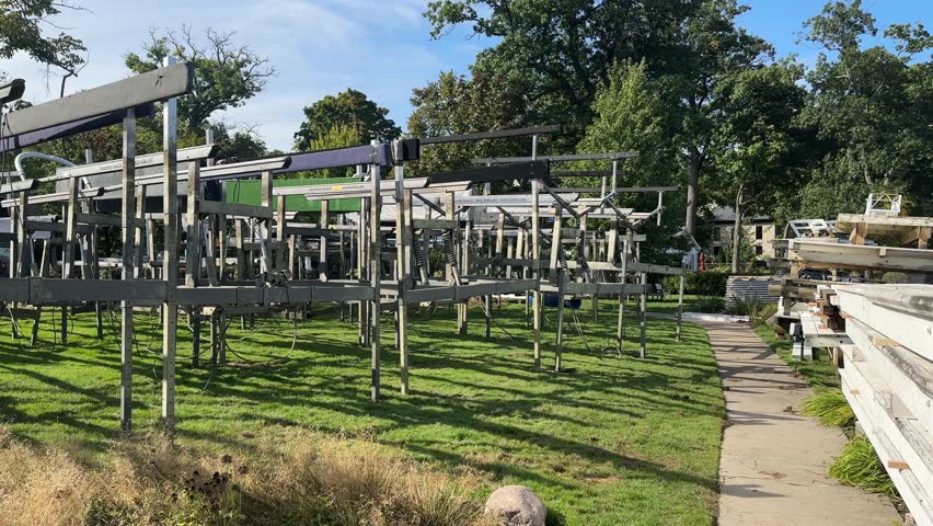 Boat Lifts On Green Grass Next To Narrow Pathway Near Lake Geneva In Wisconsin, USA. wide shot