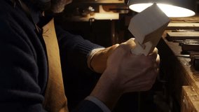 Close-up of a skilled luthier carving the scroll of a violin under warm light in a woodshop. The artisan works with focus and precision, shaping the fine details of the instrument volute by hand. - Powered by Shutterstock - Get 15% off with code: PIKWIZARD15