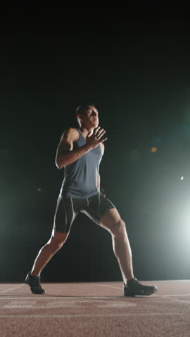 focused athlete man preparing for sprint vertical slow motion fullhd moment of concentration discipline motivation energy health body awareness strength purpose balance athletic lifestyle