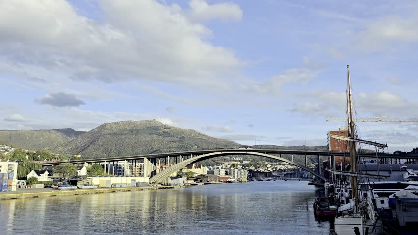Wide static shot of morning traffic on Puddefjords Bridge with reflections in calm Damsgardsundet water