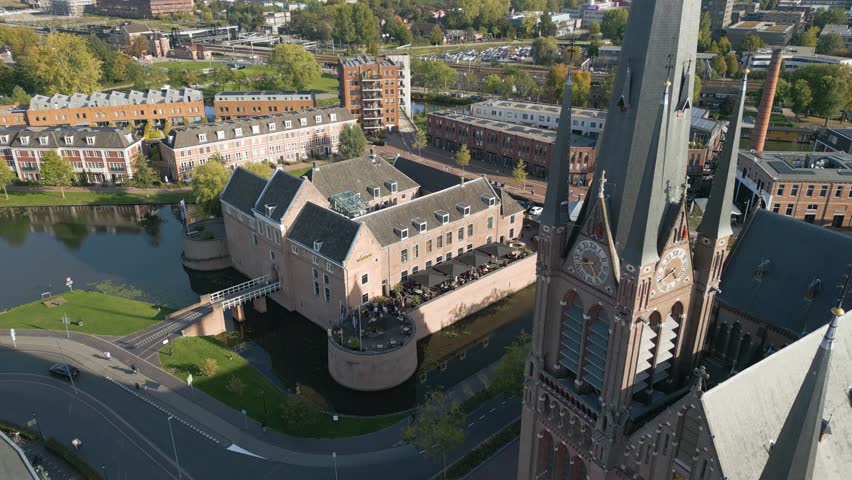 Drone footage of Woerden showing Het Kasteel van Woerden and the church tower surrounded by water and historic buildings. Captures the unique architecture and heritage of this Dutch city from above.