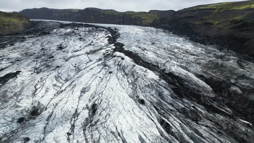 Aerial panoramic establishing of Solheimajokull Glacier, Iceland, melting pathways