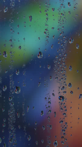 Rain-splattered windowpane with water droplets gently sliding in dim evening light, moody soft focus, ambient atmosphere, soothing scene, perfect for cinematic, introspective, melancholic visuals.