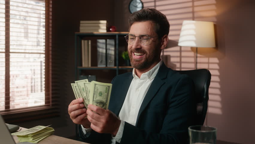 Excited happy Caucasian business man counting money middle-aged professional male businessman count cash dollars finance wealth rich in office at table satisfied job salary financial achieve executive
