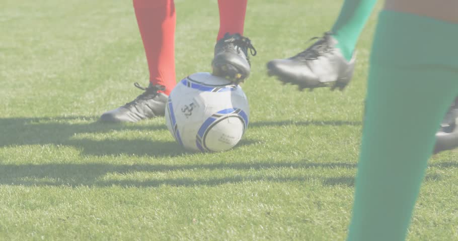 Soccer red-socks player placing cleat on turf ball sparking possession duel with binary overlay. Athletic, competition, teamwork, outdoor, dynamic, sport, intensity