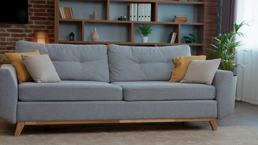 Happy caucasian family falling down on couch at own home father with daughter celebrate moving day relocation funny dad with child kid girl jumping on soft break relaxation resting playing laughing