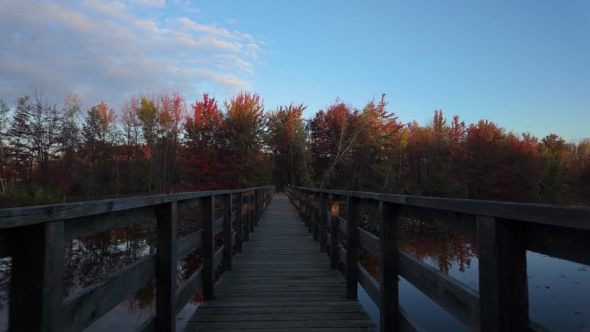 Wooden Walkway Across The River With Autumn Nature Landscape At Sunset Near Sainte-Julie In Quebec, Canada. POV Shot