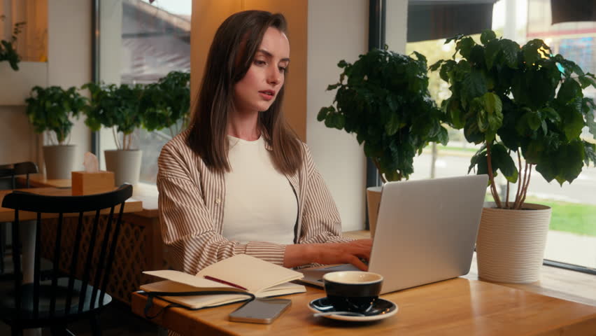 Caucasian business woman laptop working remote writing notes sitting in cafe chatting with clients internet female freelancer girl at cafeteria table work online write ideas in notebook study distant