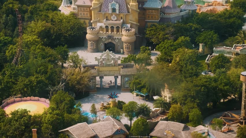 Aerial view of fairy tale castle and amusement park surrounded by lush greenery in Central of Vinwonders theme park Vinpearl on Phu Quoc island, Vietnam. Entertainment promotion, family adventure