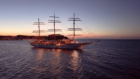 sunset ship glow, tranquil sunset voyage aboard grand threemasted vessel with reflective waters. Calvi. Corse. France - Powered by Shutterstock - Get 15% off with code: PIKWIZARD15