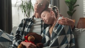 Caucasian family cuddling at home caring mother comforting sick daughter coughing ill wrapped in blanket on couch sad kid child girl hugging Teddy Bear cough sick love support medicine health problem - Powered by Shutterstock - Get 15% off with code: PIKWIZARD15