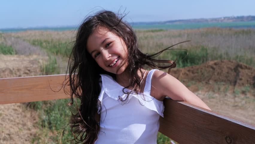 A happy and carefree young girl with her hair blowing in the wind