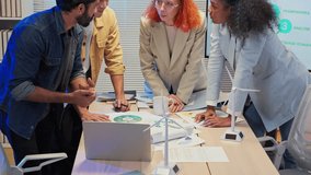 During an office night meeting, multi-ethnic business people intensely brainstorm and focus on paperwork to define goal strategy for a pivotal ESG business shift and agile transformation driving goal - Powered by Shutterstock - Get 15% off with code: PIKWIZARD15