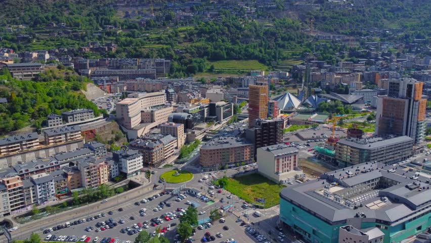 Drone footage captures a stunning aerial perspective of Andorra la Vella, the capital city of Andorra, nestled within the majestic Pyrenees Mountains between France and Spain.
