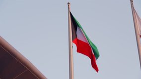 Qatar national flag waves gracefully on a tall flagpole under a soft sunset sky. Symbol of national pride, unity, and independence in the Arabian Gulf. Represents Doha, culture, and prosperity - Powered by Shutterstock - Get 15% off with code: PIKWIZARD15