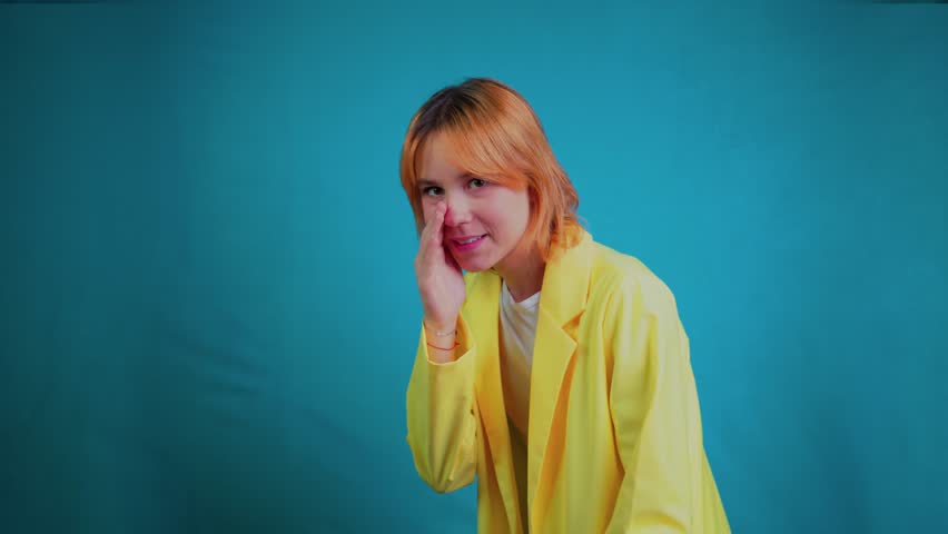 Young woman laughing hysterically and pointing at something funny