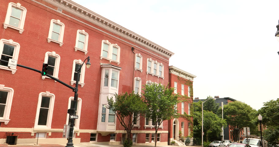 A historic wrought iron street light frames historic architecture in the Mount Vernon neighborhood of Baltimore, Maryland, USA.