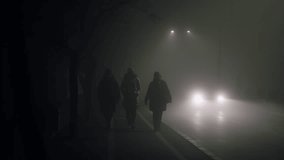 Group of unrecognizable people walking down a street in the fog. The street is empty and the car is parked on the side of the road - Powered by Shutterstock - Get 15% off with code: PIKWIZARD15