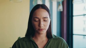 Portrait of smiling businesswoman making online video call and waving at camera using earphones in office - Powered by Shutterstock - Get 15% off with code: PIKWIZARD15