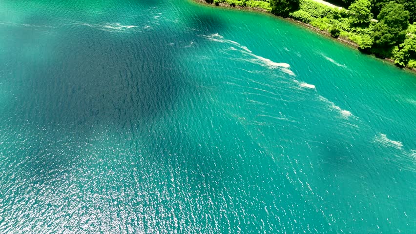 A Sunny Day Over a Blue Water Lake with Mountains Covered in Trees