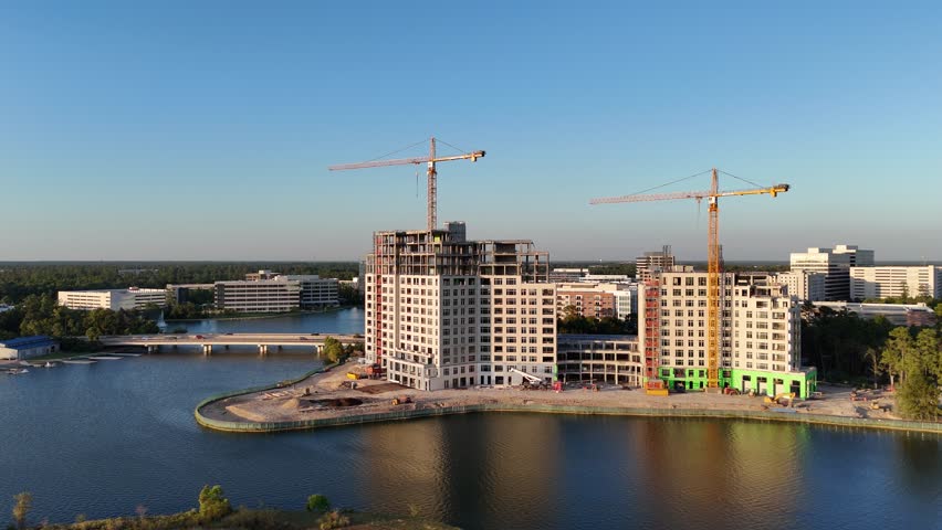 Ongoing construction of two buildings between green area in front of beautiful lake