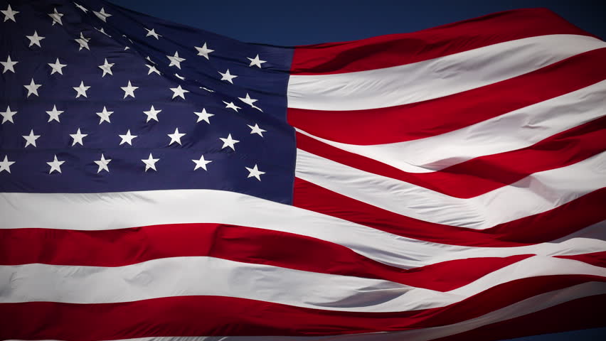 4k Slow Motion Seamless Looping Real American Flag Waving In Wind Against a Deep Blue Sky.