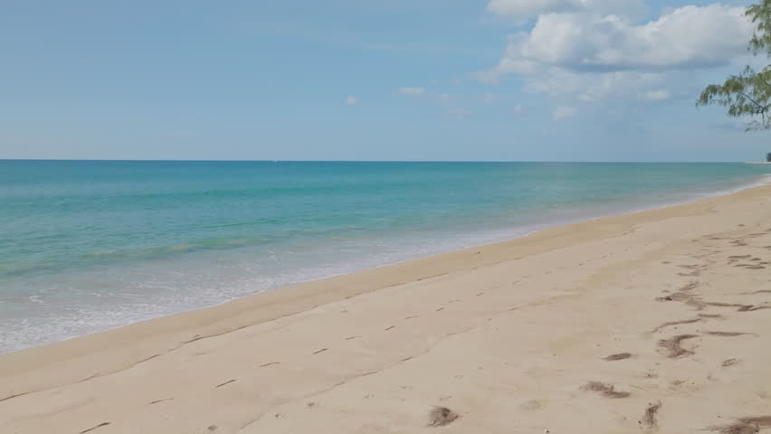Summer sea background,Blue sky white clouds over ocean waves break on sand beach,Waves crashing against an empty beach High quality video