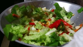 Stir-frying mixed vegetables including mustard greens, cabbage, bell pepper, and corn, evenly mixed with a spatula while cooking. - Powered by Shutterstock - Get 15% off with code: PIKWIZARD15