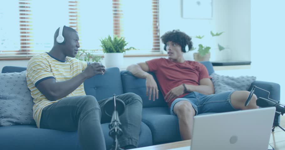 Podcast duo sitting on sofa adjusting mic recording conversation sparking data floating around team. Tech, collaboration, communication, modern, casual, multimedia, digital